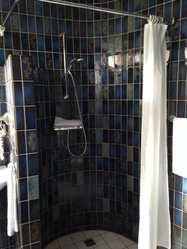 a bathroom with a shower with a shower curtain at Hotel Spaander BW Signature Collection in Volendam