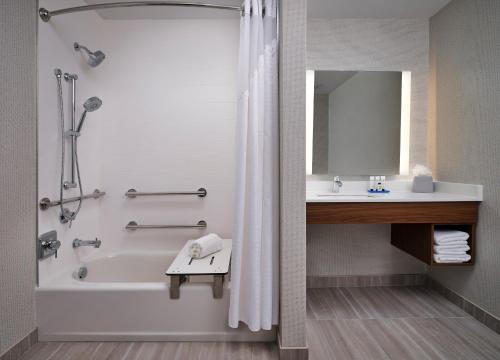 a bathroom with a shower and a tub and a sink at Holiday Inn Express & Suites - Lockport, an IHG Hotel in Lockport