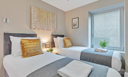 1 dormitorio con 2 camas y ventana en Ocean Walk - By My Getaways - Free Parking, en Brighton & Hove