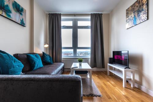 a living room with a couch and a tv at Large 2 Bedroom Apartment in Ashford with PARKING in Ashford