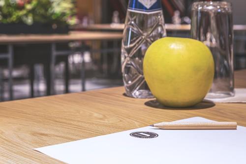a green apple sitting on top of a table at Hotel Urban in Plovdiv