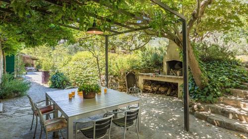 a table and chairs under a pergola with a fireplace at CONTESSA MATILDE 16, Emma Villas in Collazzone