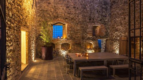 a dining room with a table and a stone wall at CONTESSA MATILDE 16, Emma Villas in Collazzone