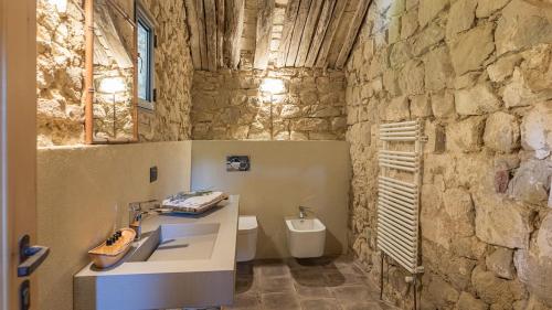 a stone bathroom with a sink and a toilet at CONTESSA MATILDE 16, Emma Villas in Collazzone