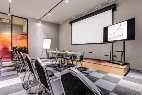 a meeting room with a table and chairs and a screen at Hotel Urban in Plovdiv