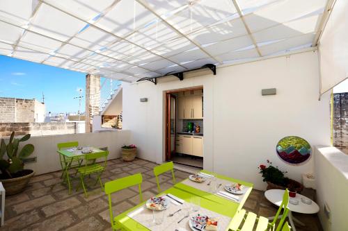 een terras met groene stoelen en tafels op een gebouw bij Elamar Rooms & Apartment in Gallipoli