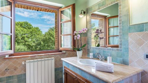 ein Bad mit einem Waschbecken und einem Fenster in der Unterkunft Il Casale Di Manuele 12, Emma Villas in Montepulciano