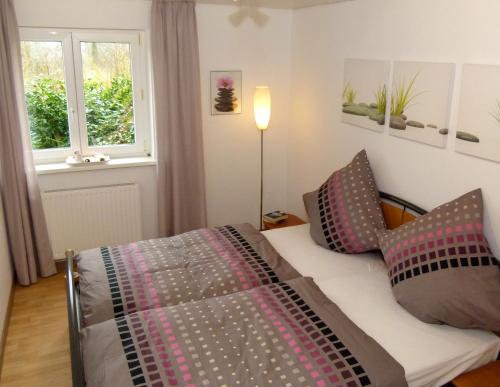 sypialnia z łóżkiem z poduszkami i oknem w obiekcie Haus Tannenweg w mieście Zell an der Mosel
