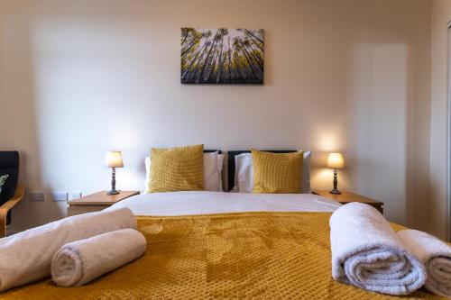 a bedroom with a large bed with towels on it at Large 2 Bedroom Apartment in Ashford with PARKING in Ashford