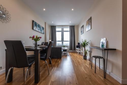 a dining room and living room with a table and chairs at Large 2 Bedroom Apartment in Ashford with PARKING in Ashford