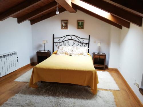- une chambre avec un grand lit jaune et 2 tables de chevet dans l'établissement Apartamento Peña Sol B (Bustio), à Bustio