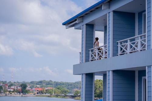 a woman standing on the balcony of a building at Hotel Casona del Lago in Flores