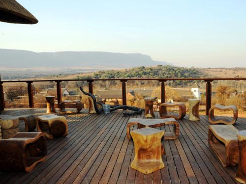 a wooden deck with chairs and tables on a view at African Hills Safari Lodge & Spa in Magaliesburg