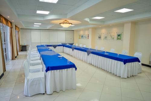 a conference room with blue tables and white chairs at Hotel Casona del Lago in Flores