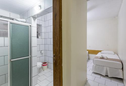a bathroom with a toilet and a glass shower door at Hotel Marjaí in Itajaí