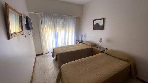 a hotel room with two beds and a window at 3 ambientes - Departamento reciclado a nuevo a 250m del mar in Miramar