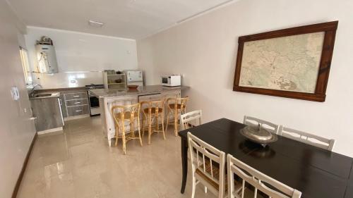 a kitchen with a black table and chairs and a counter at 3 ambientes - Departamento reciclado a nuevo a 250m del mar in Miramar