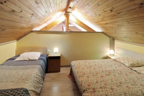 1 Schlafzimmer mit 2 Betten und Holzdecke in der Unterkunft Appartement de 2 chambres avec wifi a Echenans in Échenans