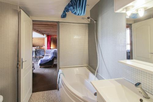 ein Badezimmer mit einer Badewanne und einem Waschbecken in der Unterkunft Appartement de 2 chambres avec wifi a Echenans in Échenans
