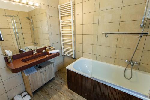 a bathroom with a bath tub and a sink at Pensiunea Carmen`s Mansion B in Sinaia