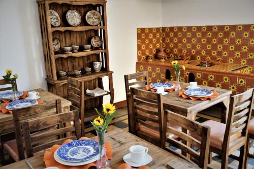 a dining room with wooden tables and chairs and plates at Quinta Alhóndiga Galindo Hotel Boutique in Cholula