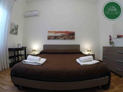 1 dormitorio con 1 cama con 2 toallas en La Casetta, en Palermo