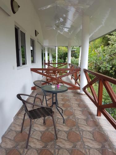 a patio with a table and chairs on a porch at Magic Mountain Lodge in Las Lajas