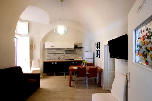 a kitchen and dining room with a table and a dining room at Elamar Rooms & Apartment in Gallipoli