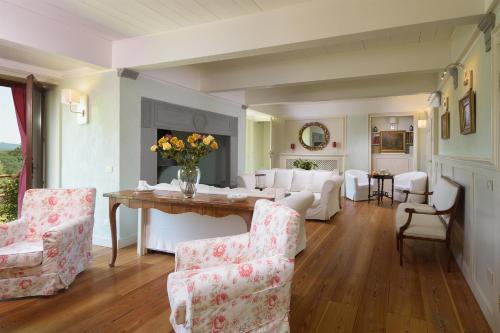 a living room with white furniture and a table and chairs at Villa La Poiana 10 Emma Villas in Radda in Chianti