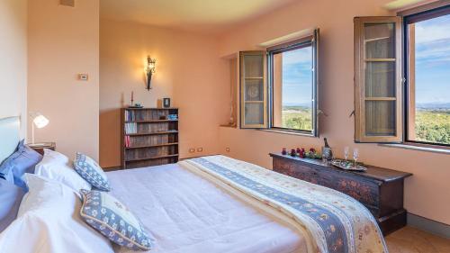 ein Schlafzimmer mit einem großen Bett und zwei Fenstern in der Unterkunft VILLA IL FORAMASSO 10&2, Emma Villas in Lucciana