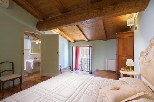 a bedroom with a large bed with a wooden ceiling at Villa La Poiana 10 Emma Villas in Radda in Chianti