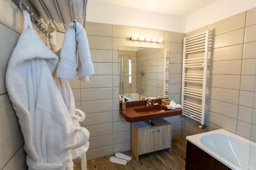 a bathroom with a sink and a tub and a mirror at Pensiunea Carmen`s Mansion B in Sinaia