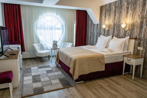 a hotel room with a bed and a table and chairs at Pensiunea Carmen`s Mansion B in Sinaia