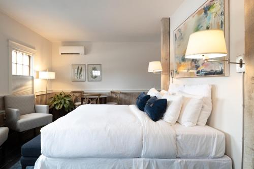 a bedroom with a large white bed and a chair at The Water Street Inn in Kittery