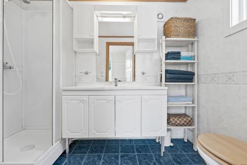 a white bathroom with a sink and a mirror at Fishermans Village Lofoten in Alstad