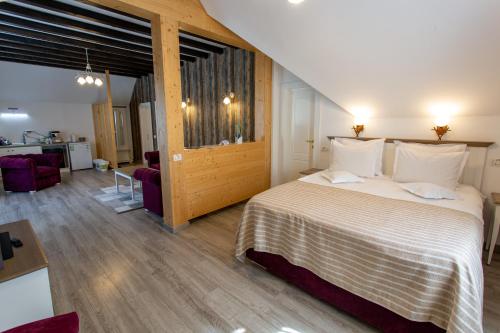 a bedroom with a bed and a living room at Pensiunea Carmen`s Mansion B in Sinaia