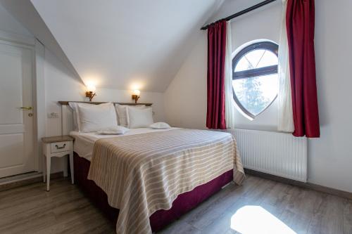 a small bedroom with a bed and a window at Pensiunea Carmen`s Mansion B in Sinaia