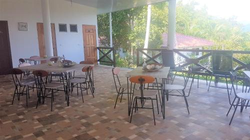 a room with tables and chairs and a balcony at Magic Mountain Lodge in Las Lajas