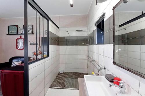 un bagno bianco con lavandino e doccia di Les Pérelles a Saint-Vigor-le-Grand