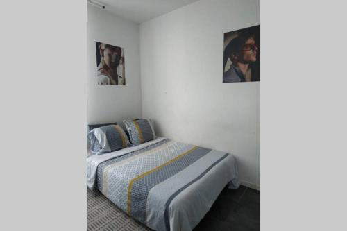 a bedroom with a bed and two pictures on the wall at Studio Cosy et fonctionnel drancy CDG in Drancy