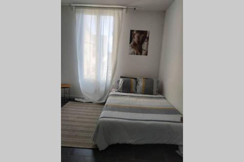 a bedroom with a bed and a window at Studio Cosy et fonctionnel drancy CDG in Drancy
