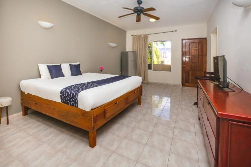 1 dormitorio con 1 cama y TV de pantalla plana en Hotel Kiin Cozumel en Cozumel