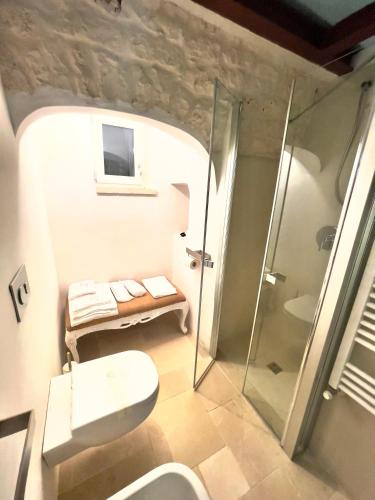 a bathroom with a toilet and a glass shower at Tenuta Ermes in Ostuni