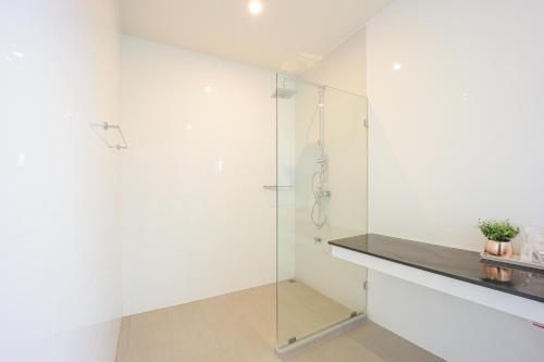 a white bathroom with a glass shower stall at AKARD Private Villas Sattahip in Sattahip