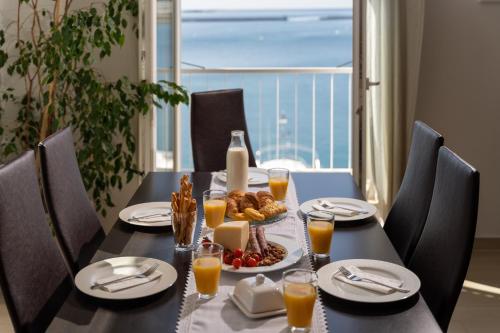a black table with a plate of food and orange juice at Design Apartment Bellevue in Poreč