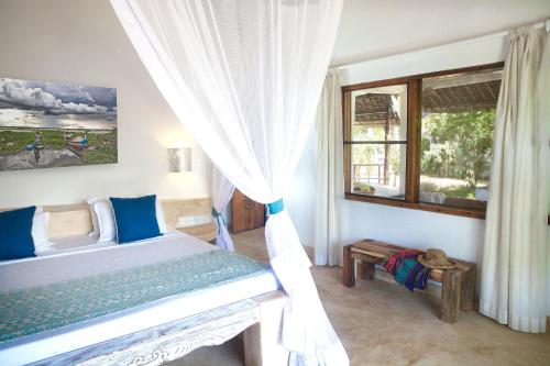 a bedroom with a bed and a window at Temple Point Resort in Watamu
