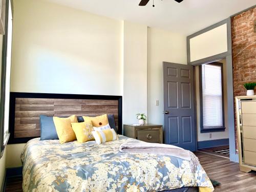 a bedroom with a large bed with yellow and blue pillows at Perfect 6BR Stay Near Falls & Attractions in Niagara Falls