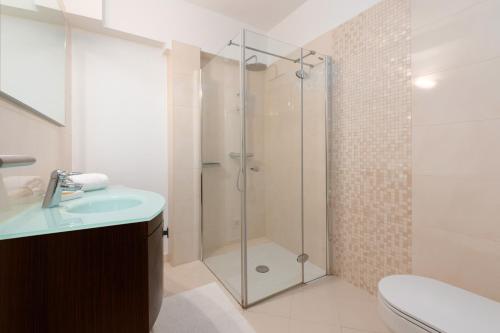 a bathroom with a shower with a sink and a toilet at Design Apartment Bellevue in Poreč