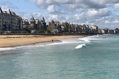 a beach with a group of people in the water at IDEAL - Plage, jardin & jacuzzi, proche plage et thalasso - 1 à 6 personnes in Saint Malo