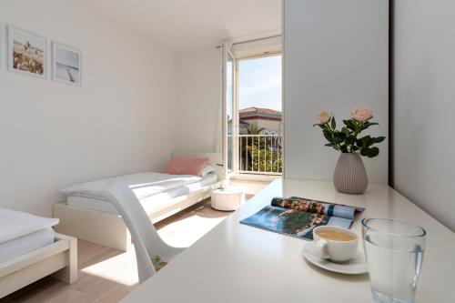 Habitación blanca con cama y mesa con una taza de café en Design Apartment Bellevue en Poreč